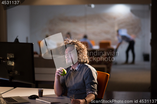 Image of man working on computer in dark office