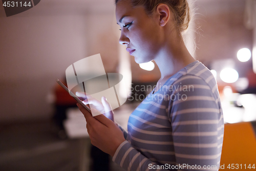 Image of woman working on digital tablet in night office