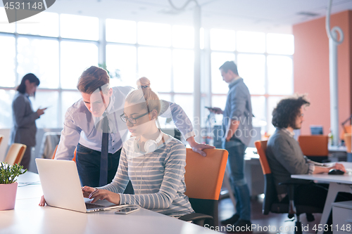 Image of Two Business People Working With laptop in office