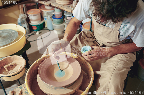 Image of Creating a jar or vase of white clay close-up. Master crock.