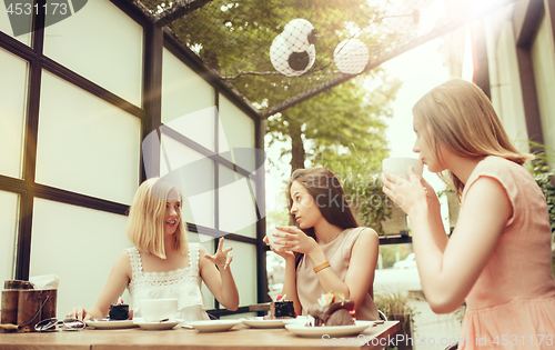 Image of Two girl friends spend time together drinking coffee in the cafe, having breakfast and dessert.