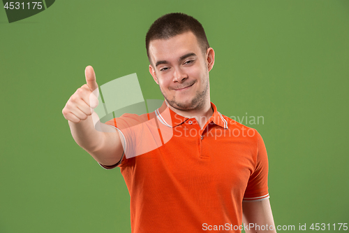 Image of The happy businessman standing and smiling against green background.