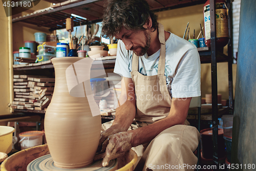 Image of Creating a jar or vase of white clay close-up. Master crock.