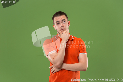 Image of Young serious thoughtful businessman. Doubt concept.