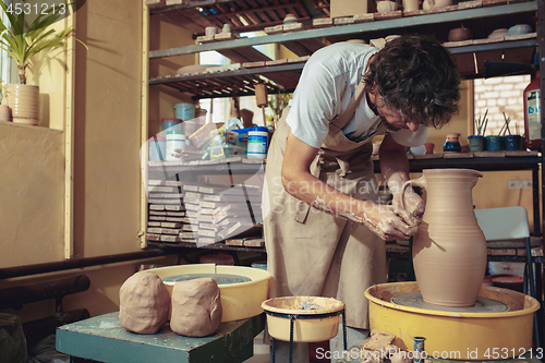 Image of Creating a jar or vase of white clay close-up. Master crock.