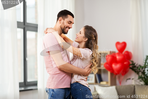 Image of happy couple hugging at home on valentines day