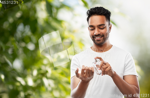 Image of indian man with perfume over natural background