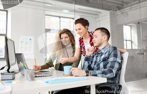 Image of creative team with laptop working at office