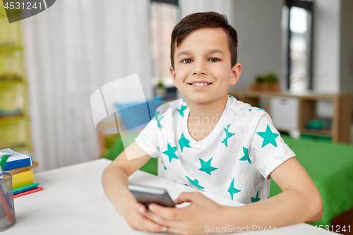 Image of happy boy with smartphone at home