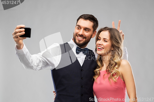 Image of happy couple taking selfie by smartphone