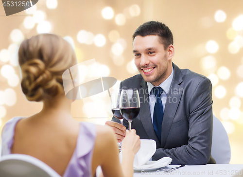 Image of young couple with glasses of wine at restaurant