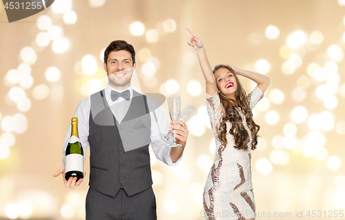 Image of man with bottle of champagne and glasses at party