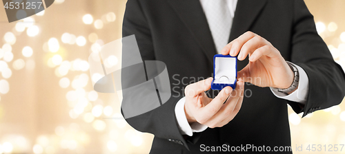 Image of man with diamond engagement ring in red gift box