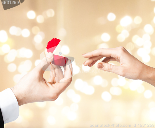 Image of man giving diamond ring to woman on valentines day