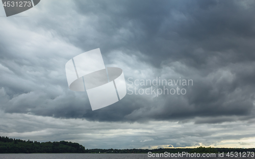 Image of Dramatic Overcast Sky With Thunderclouds Over The Lake