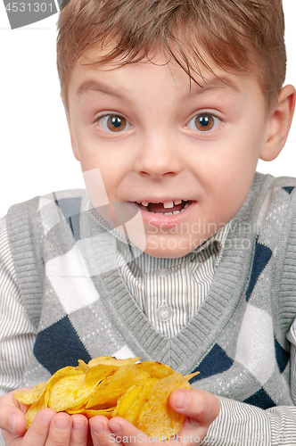 Image of Little boy is eating chips