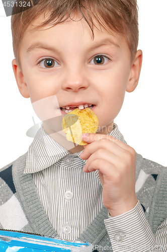 Image of Little boy is eating chips