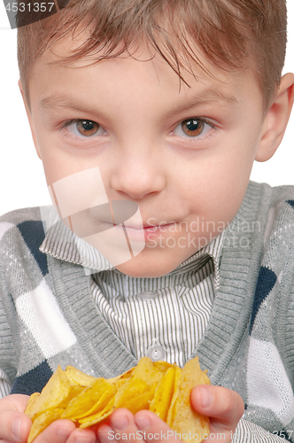 Image of Little boy is eating chips