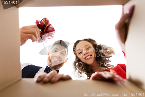 Image of happy couple opening christmas gift box