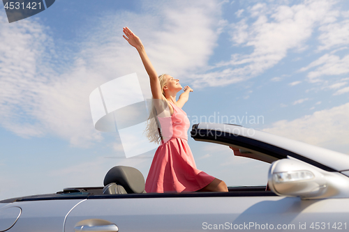 Image of happy young woman in convertible car