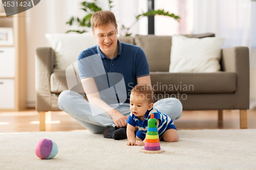 Image of happy father with little baby son playing at home