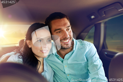 Image of happy man and woman riding in a taxi back seat