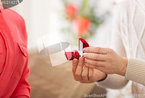 Image of man giving diamond ring to woman on valentines day