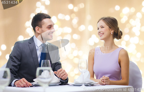 Image of happy couple at restaurant over festive lights