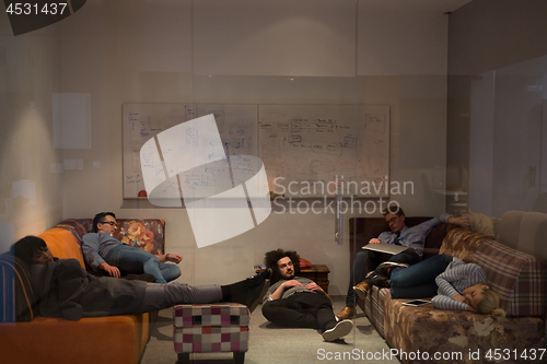 Image of software developers sleeping on sofa in creative startup office