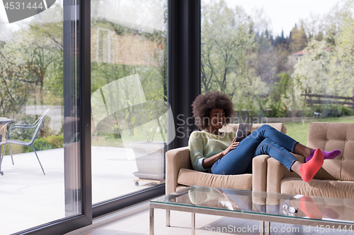 Image of young african american woman at home using digital tablet