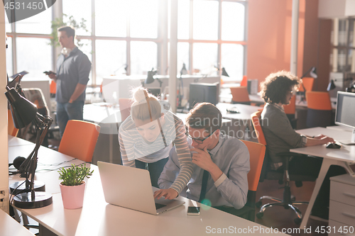 Image of Two Business People Working With laptop in office