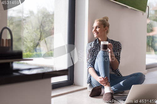 Image of young woman drinking coffee enjoying relaxing lifestyle