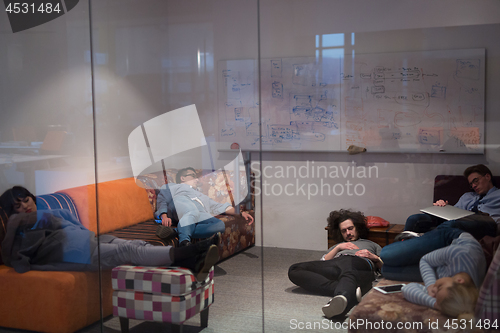 Image of software developers sleeping on sofa in creative startup office
