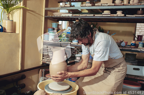 Image of Creating a jar or vase of white clay close-up. Master crock.