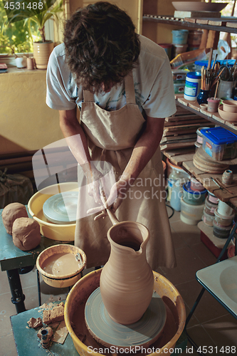 Image of Creating a jar or vase of white clay close-up. Master crock.