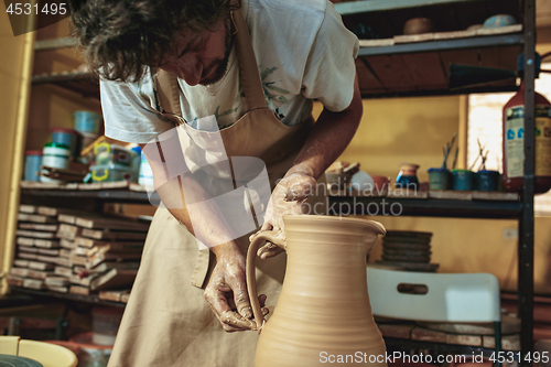 Image of Creating a jar or vase of white clay close-up. Master crock.