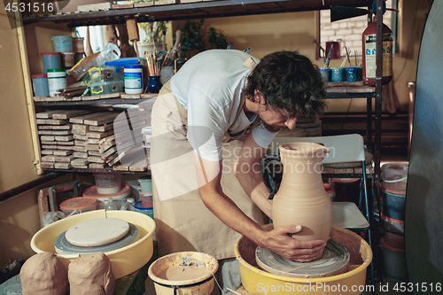 Image of Creating a jar or vase of white clay close-up. Master crock.