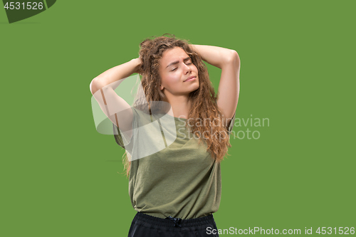 Image of Woman having headache. Isolated over green background.