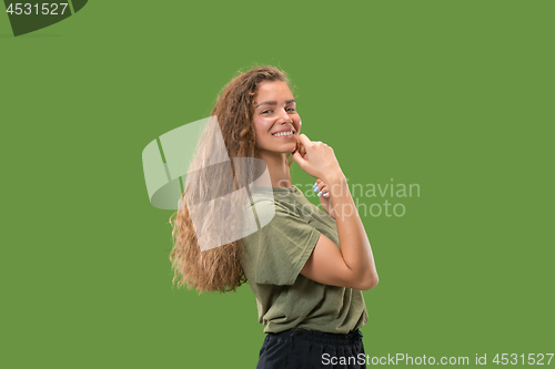 Image of The happy woman standing and smiling against green background.