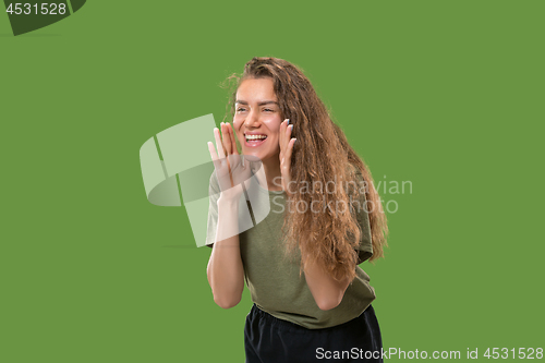 Image of Isolated on green young casual woman shouting at studio