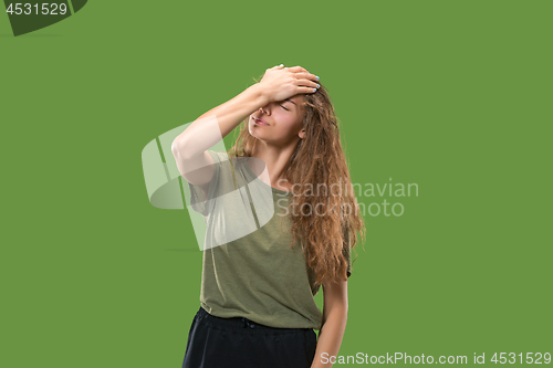 Image of Woman having headache. Isolated over green background.