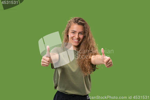 Image of The happy business woman standing and smiling against green background.