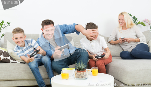 Image of Happy young family playing videogame On TV.