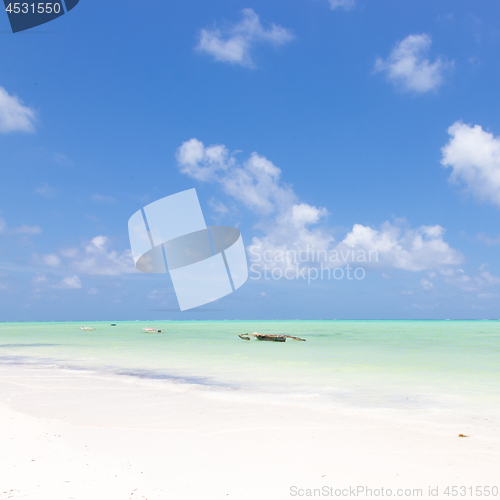 Image of Fishing boat on picture perfect white sandy beach with turquoise blue sea, Paje, Zanzibar, Tanzania.