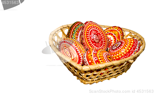 Image of Wooden Easter eggs in a wicker basket, hand-painted with acrylic paints, isolated on a white background.