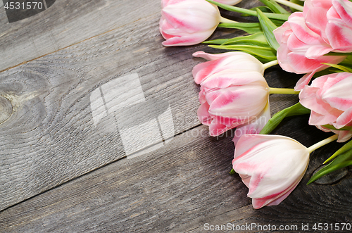 Image of Bouquet of pink tulips on the background of old wooden boards with a place for the inscription, toned