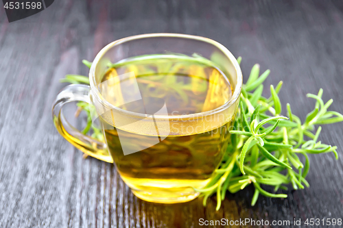 Image of Tea of rosemary in cup on dark wooden board