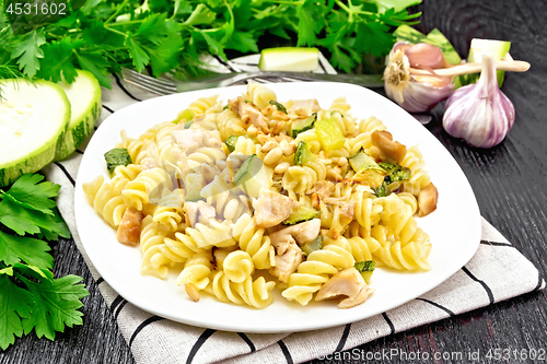 Image of Fusilli with chicken and zucchini in plate on napkin