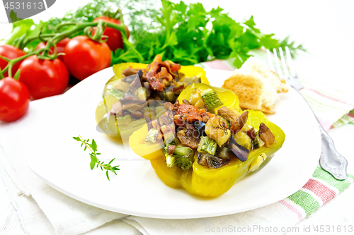 Image of Pepper stuffed with vegetables in plate on light board