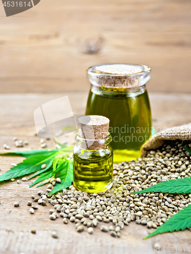Image of Oil hemp in two jars with grain on old board